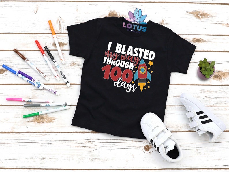 May include: Black t-shirt with a rocket ship graphic and the text "I blasted my way through 100 days".