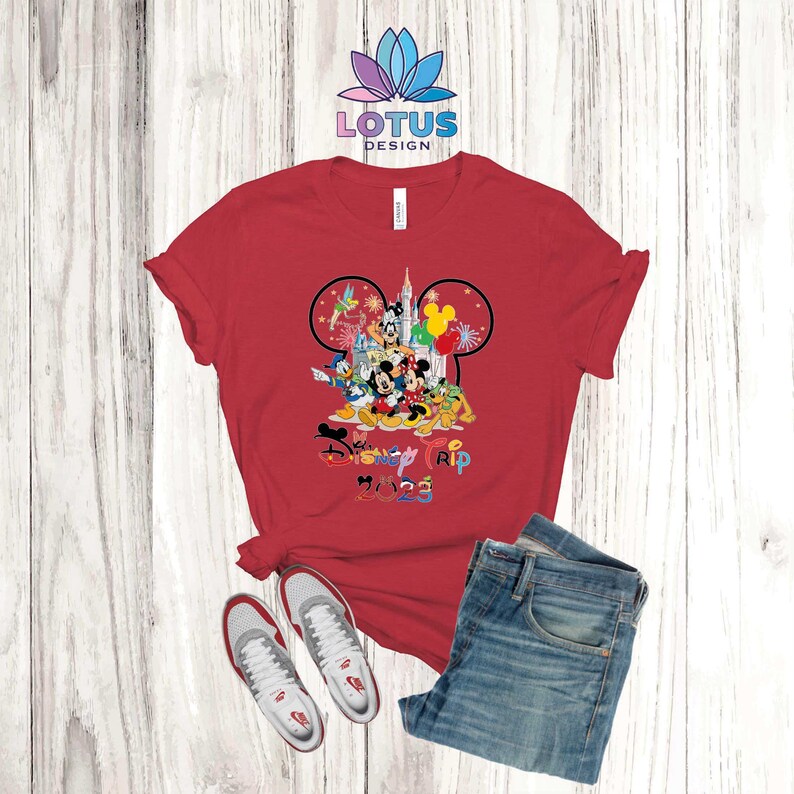 Puede incluir: Camiseta roja con un gr&aacute;fico de Mickey Mouse y otros personajes de Disney frente al Castillo de Cenicienta. El texto "My Disney Trip 2023" est&aacute; impreso debajo del gr&aacute;fico.