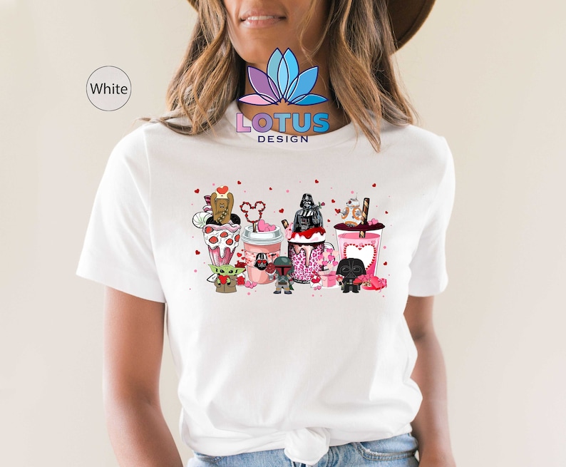May include: White t-shirt with a graphic of Star Wars characters enjoying Valentine's Day themed treats. The characters include Darth Vader, Yoda, Chewbacca, and others. The text "LOTUS DESIGN" is printed on the shirt.