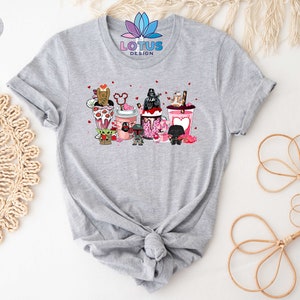 May include: Gray t-shirt with a graphic of Star Wars characters holding Valentine's Day themed drinks. The text "LOTUS DESIGN" is printed on the shirt.