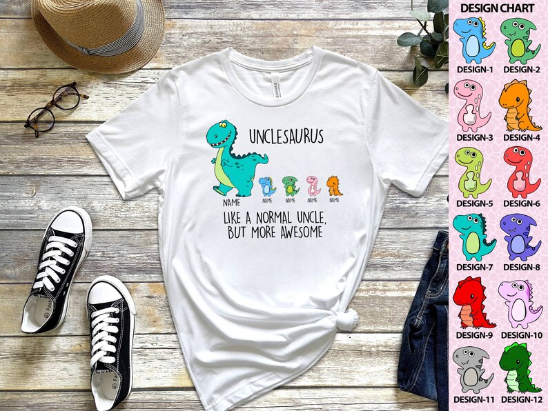 Op de afbeelding: Wit T-shirt met een cartoon dinosaurusafbeelding en de tekst "UNCLESAURUS". Het shirt heeft ook kleinere dinosaurusontwerpen en de zin "LIKE A NORMAL UNCLE, BUT MORE AWESOME".