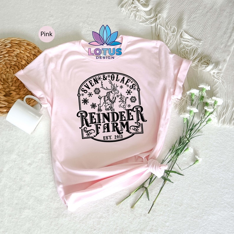 May include: Pink t-shirt with a black graphic of a reindeer and Olaf from Frozen. The graphic says "Sven & Olaf's Reindeer Farm Est. 2013".