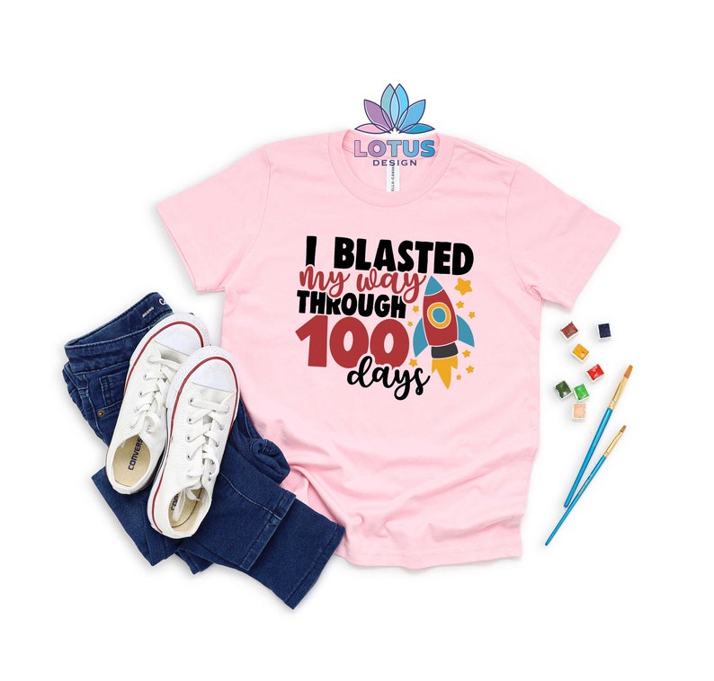 May include: Pink t-shirt with a rocket ship graphic and the text "I blasted my way through 100 days".