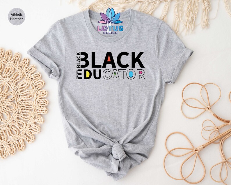 May include: A gray t-shirt with the text "I'm Black Educator" in colorful letters. The text is in a bold, blocky font.