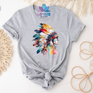 May include: Gray t-shirt with a watercolor illustration of a Native American woman wearing a colorful headdress. The text "LOTUS DESIGN" is printed on the shirt.
