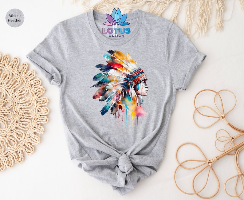 May include: Gray t-shirt with a watercolor illustration of a Native American woman wearing a colorful headdress. The text "LOTUS DESIGN" is printed on the shirt.
