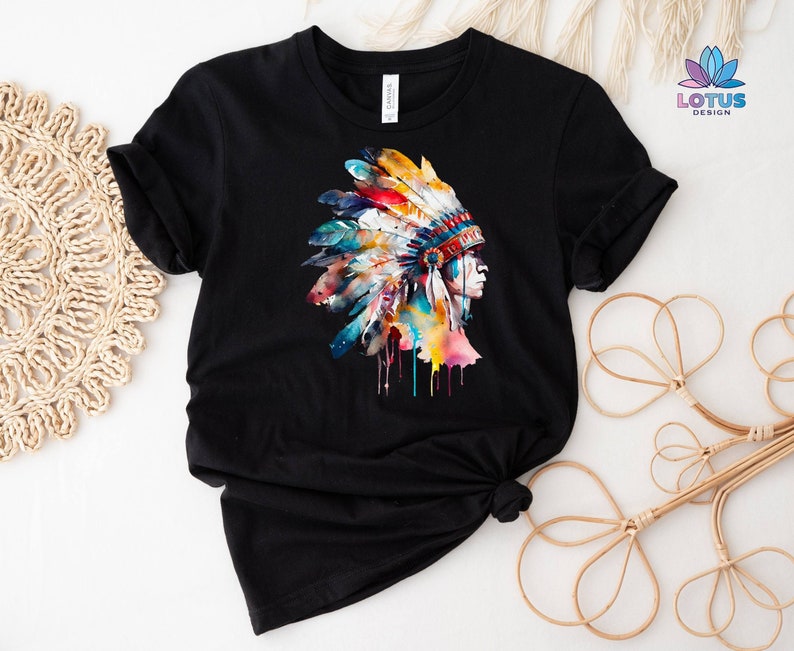 May include: Black t-shirt with a colorful watercolor illustration of a Native American headdress. The headdress is made of feathers and beads and has a colorful design.