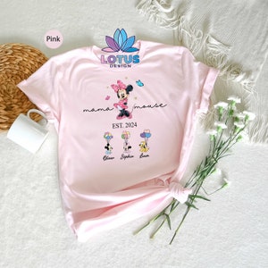 Puede incluir: Camiseta rosa con un gr&aacute;fico de Minnie Mouse sosteniendo globos con el texto "mama mouse EST. 2024" y los nombres "Oliver, Sophia, Liam" impresos debajo.