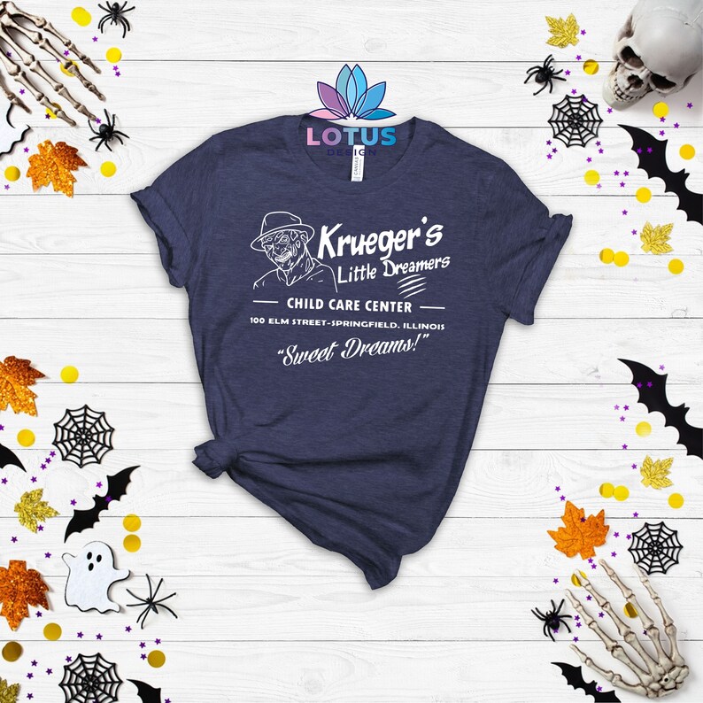 May include: A navy blue t-shirt with a white graphic of a child care center called "Krueger's Little Dreamers". The graphic includes a cartoon of Freddy Krueger, the fictional character from the Nightmare on Elm Street film series. The text on the graphic reads "Child Care Center", "100 Elm Street-Springfield, Illinois", and "Sweet Dreams!"