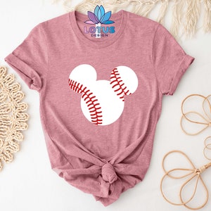 May include: A pink t-shirt with a white baseball Mickey Mouse design. The shirt is tied in a knot at the bottom.