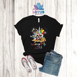Puede incluir: Camiseta negra con un gr&aacute;fico de Mickey Mouse y otros personajes de Disney frente al Castillo de Cenicienta. El texto "My Disney Trip 2023" est&aacute; impreso debajo de los personajes.
