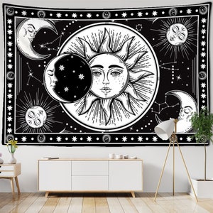 May include: Black and white tapestry featuring celestial imagery. The design includes a central sun with a face, surrounded by moons, stars, and constellations. The border is decorated with stars. The tapestry is rectangular and suitable for wall decor.