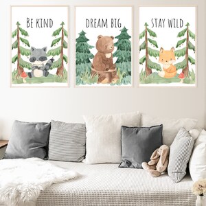 May include: Three watercolor illustrations of woodland animals with inspirational quotes. The first image features a raccoon with the quote "Be Kind". The second image features a bear with the quote "Dream Big". The third image features a fox with the quote "Stay Wild".