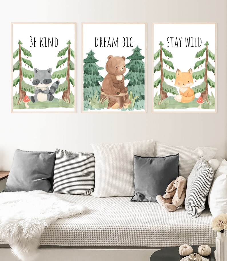 May include: Three watercolor illustrations of woodland animals with inspirational quotes. The first image features a raccoon with the quote "Be Kind". The second image features a bear with the quote "Dream Big". The third image features a fox with the quote "Stay Wild".