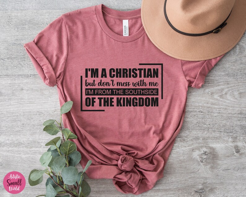 May include: A maroon t-shirt with the text "I'M A CHRISTIAN but don't mess with me I'M FROM THE SOUTHSIDE OF THE KINGDOM" printed in black.