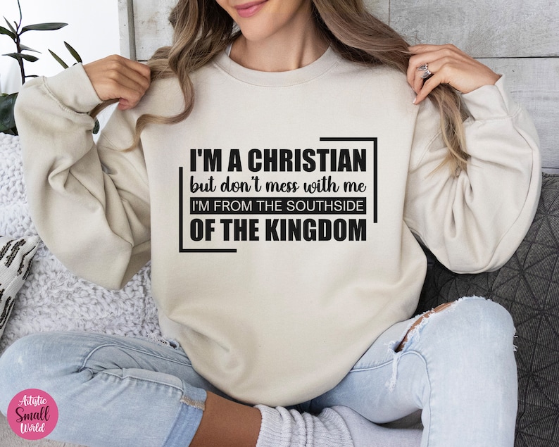 May include: A beige sweatshirt with black text that reads "I'M A CHRISTIAN but don't mess with me I'M FROM THE SOUTHSIDE OF THE KINGDOM".
