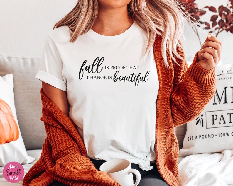 Puede incluir: Camiseta blanca con el texto "fall is proof that change is beautiful" en letras cursivas negras.