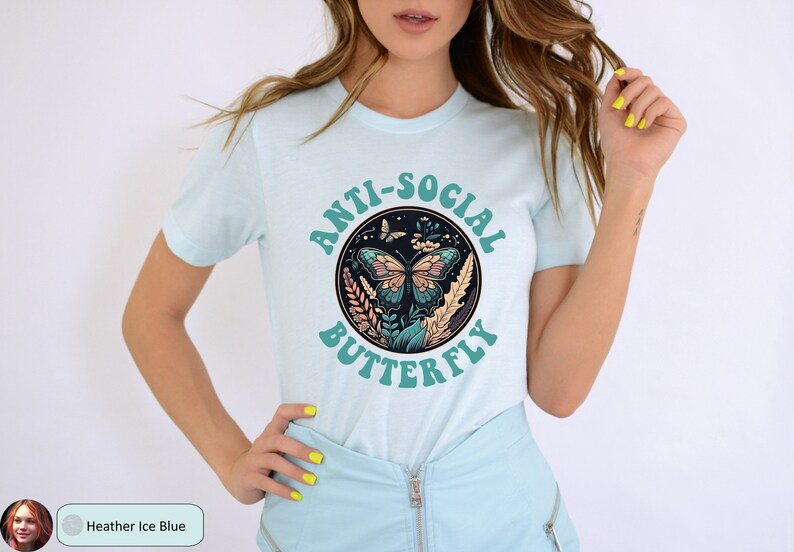 May include: A light blue t-shirt with a graphic of a butterfly in a circle with the text "Anti-Social Butterfly" in a teal color.