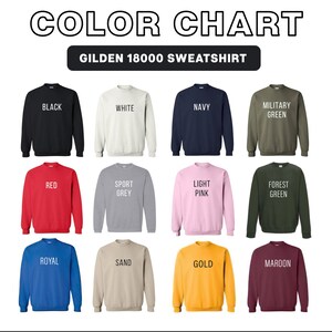 May include: Color chart of Gildan 18000 sweatshirts in various colors, including black, white, navy, military green, red, sport grey, light pink, forest green, royal blue, sand, gold, and maroon. Each sweatshirt is displayed individually.