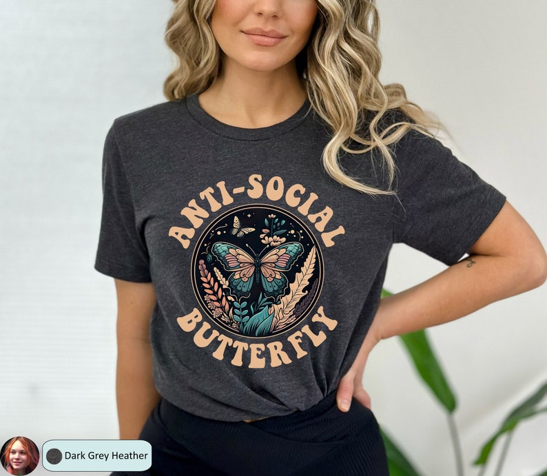 May include: A dark grey heather t-shirt with a graphic of a butterfly in a circle with the text "Anti-Social Butterfly" in a retro font.