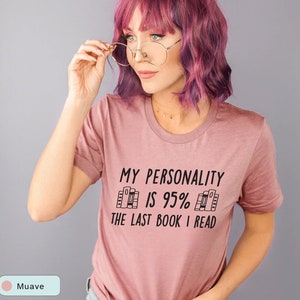 May include: A mauve t-shirt with the text "My personality is 95% the last book I read" in black. The text is surrounded by a graphic of stacked books.