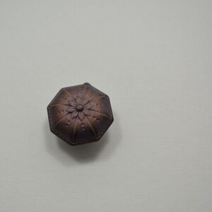 May include: Two small, octagonal, brown, decorative boxes with a floral design on the top.