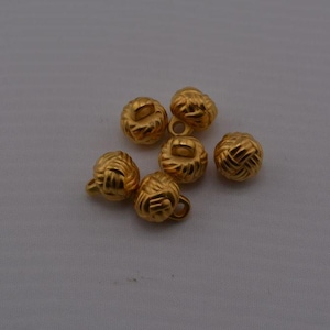 May include: Six gold-toned buttons with a rope-like design. The buttons have a shank on the back for sewing.