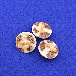 May include: Three white ceramic buttons with a brown design of acorns and leaves.