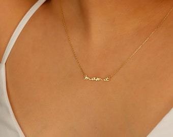 May include: A gold necklace with a delicate cursive 'mama' pendant.
