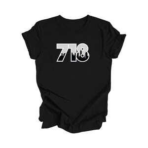 May include: Black t-shirt with a white graphic of the number 718 with a skyline silhouette inside the numbers.
