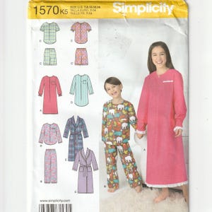 May include: Simplicity sewing pattern 1570 for children's sleepwear in sizes 7-14. The envelope features illustrations of pajamas, nightgowns, and robes in various patterns and colors, alongside photographs of two models wearing the finished garments.