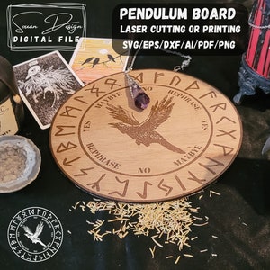 May include: A wooden pendulum board with a raven design and the words "YES", "MAYBYE", "NO", and "REPHRASE" around the edge. The board is surrounded by small wood shavings and a purple crystal pendulum.