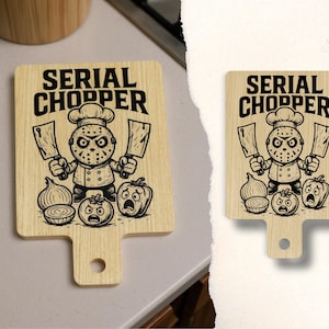 May include: Wooden cutting board with a handle, featuring a cartoon chef with a hockey mask holding cleavers. The text "SERIAL CHOPPER" is above the chef, with cartoon vegetables below.