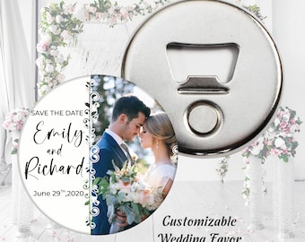 Puede incluir: Un abridor de botellas redondo de plata con un imán en la parte posterior. La parte delantera del imán presenta una foto de boda de una pareja con el texto "Save the Date Emily and Richard June 29th, 2020".