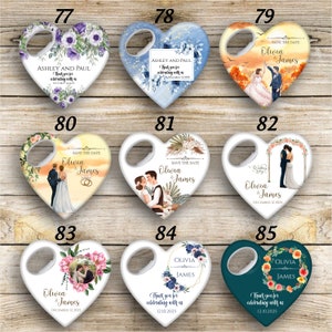 May include: Set of ten heart-shaped bottle openers with various wedding-themed designs. The designs include floral patterns, couples, and wedding arches. The bottle openers are white with a gold rim and a bottle opener on the top.
