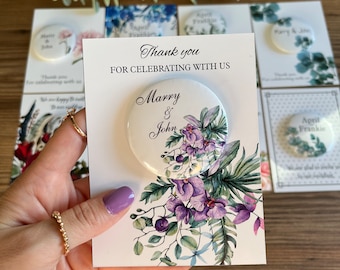 May include: Thank you for celebrating with us, Marry & John. A white card with purple and green floral design and a round button with the same design and the text "Marry & John".