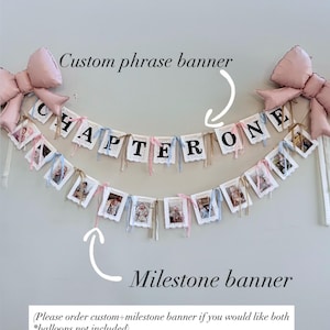 May include: A custom phrase banner and milestone banner with photos, with the text "CHAPTER ONE". The banners are white with black lettering and are decorated with pink and blue ribbons. Two large pink bows are at the top.