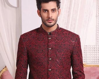 May include: A red patterned blazer with a mandarin collar and button closure. The blazer features a black and red paisley design and is embellished with sequins.