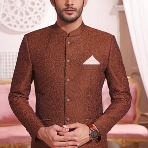 May include: A brown patterned blazer with a mandarin collar and a white pocket square. The blazer has a button closure and a single button on each cuff.
