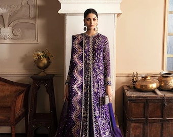May include: A formal purple gown with intricate gold embroidery. The long-sleeved dress features a floor-length skirt and a matching overcoat, creating an elegant and luxurious look. The outfit is accessorized with gold earrings and a small silver clutch.