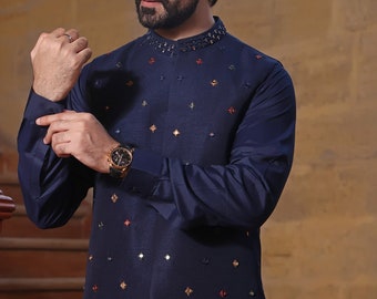 May include: A navy blue waistcoat with a mandarin collar and intricate embroidery. The waistcoat has a pattern of small, colorful squares and a border of ornate swirls.