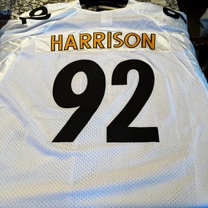 May include: A white mesh sports jersey featuring the name HARRISON in yellow letters with black outlines on a white nameplate, and the number 92 in large black numerals centered below. The jersey also displays the number 92 on the shoulders.