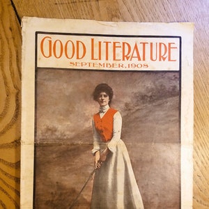 May include: A vintage magazine cover for "Good Literature, September, 1908." It shows a woman in a white dress and orange waistcoat, holding a golf club. The publisher's details are at the bottom.
