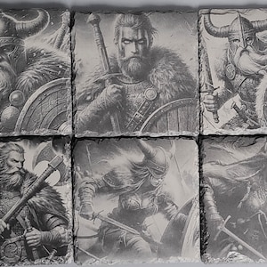 May include: Six black and white coasters featuring images of Viking warriors. Each coaster depicts a different warrior with a sword, shield, and axe. The coasters are made of slate and have a rough, textured surface.