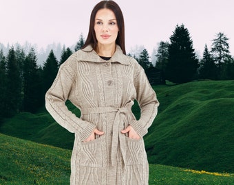May include: A beige cable-knit cardigan featuring a fold-over collar, a button-front closure, a matching tie belt at the waist, and two large patch pockets on the front. The long-sleeved garment has a textured pattern throughout the knit fabric.