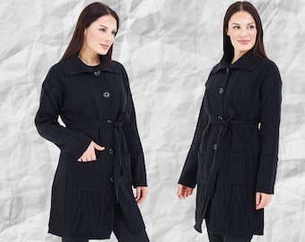 Könnte beinhalten: Eine schwarze Langarm-Strickjacke mit Zopfmuster, breitem Kragen und Knopfleiste auf der Vorderseite. Das Kleidungsstück verfügt über zwei aufgesetzte Vordertaschen und einen passenden Bindegürtel in der Taille, der für eine strukturierte Passform sorgt.