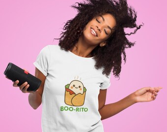 May include: White t-shirt with a cartoon burrito graphic and the text "BOO-RITO" in green. The burrito has a smiling face and is wrapped in a tortilla. The background is a solid pink color.