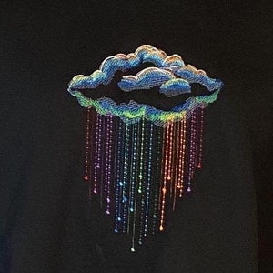 May include: Black sweatshirt with an embroidered design of a blue cloud with a rainbow of raindrops falling from it.