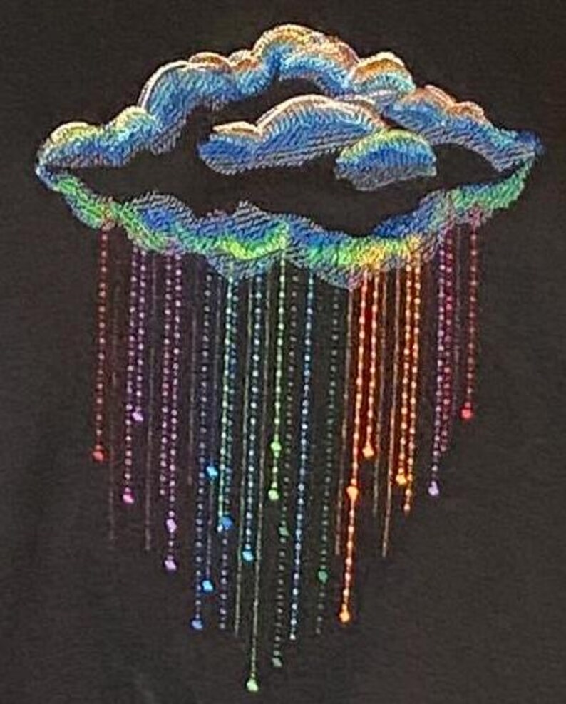 May include: A decorative cloud design with rainbow-coloured rain. The cloud is blue with iridescent detailing, and the rain is made of strings of beads in various colours. The background is black.