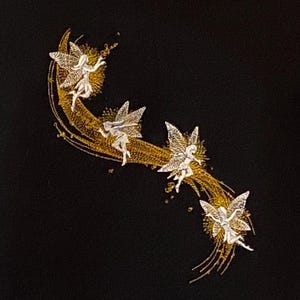 May include: Embroidered design on black fabric featuring four fairies with silver wings and white dresses. They are positioned along a gold crescent and a trail of gold lines and dots. The design is detailed and elegant.